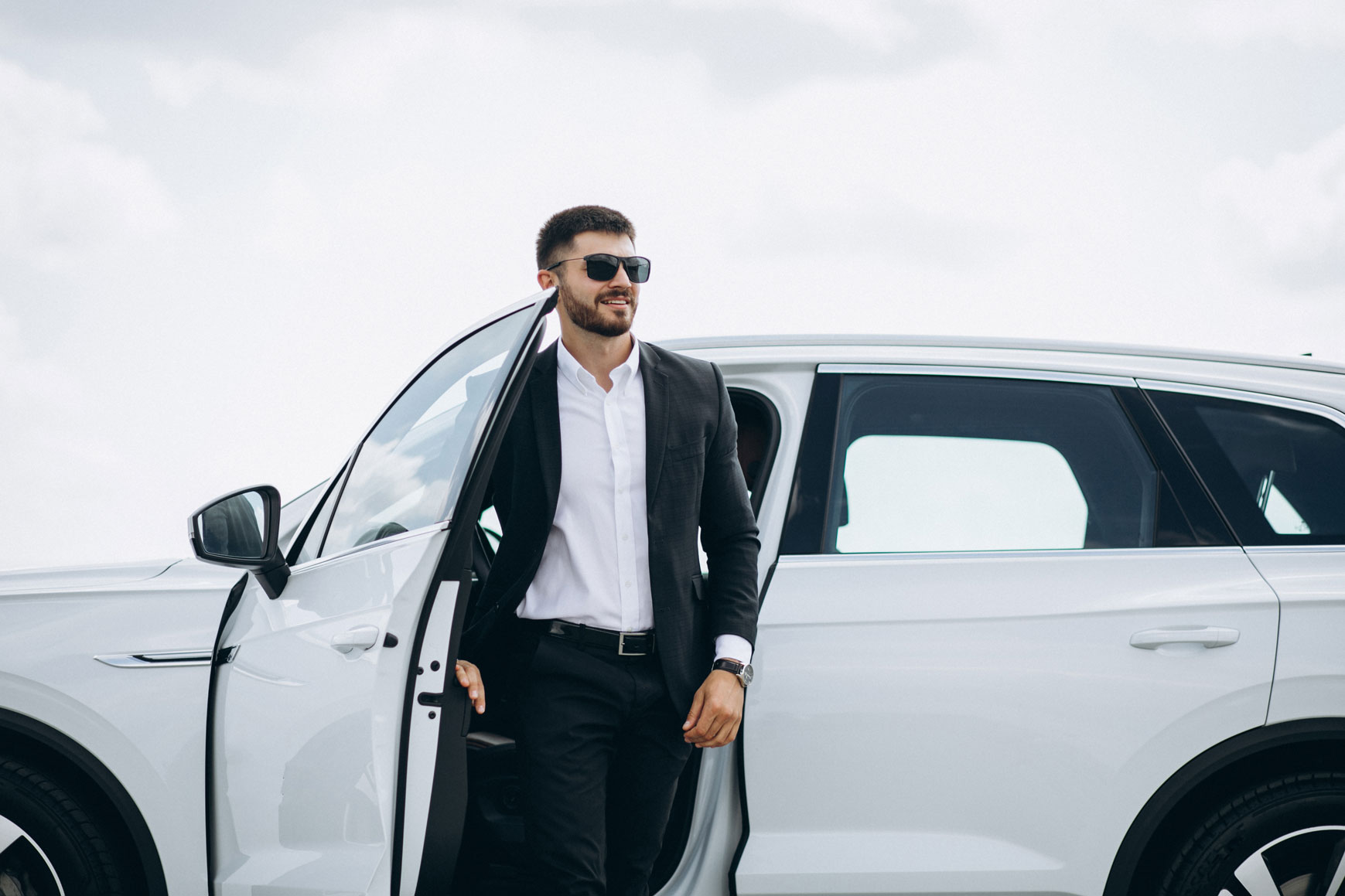 handsome business man by white car